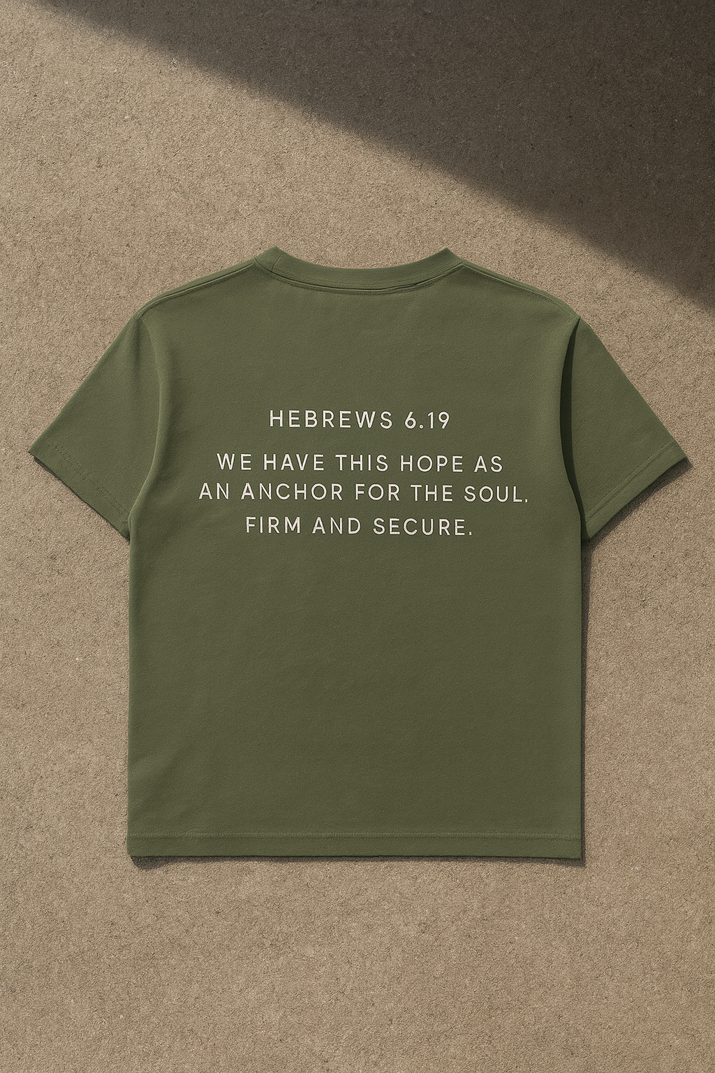 Green t-shirt with Hebrews 6:19 text on a beige background