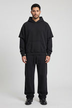 Snow-washed raw edge hoodie and sweatpants set in black, worn together