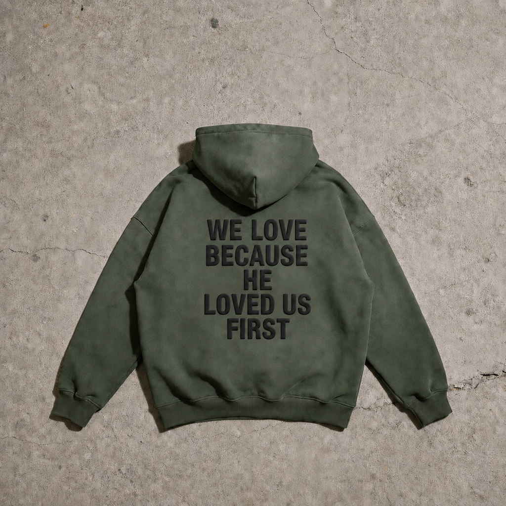 Green hoodie with text on the back on a concrete surface