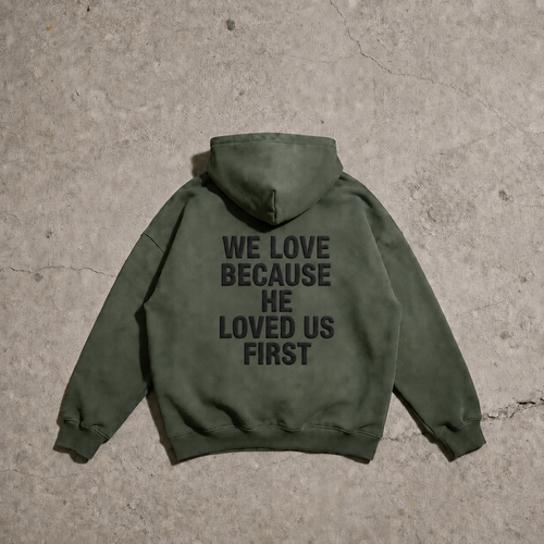 Green hoodie with text on the back on a concrete surface